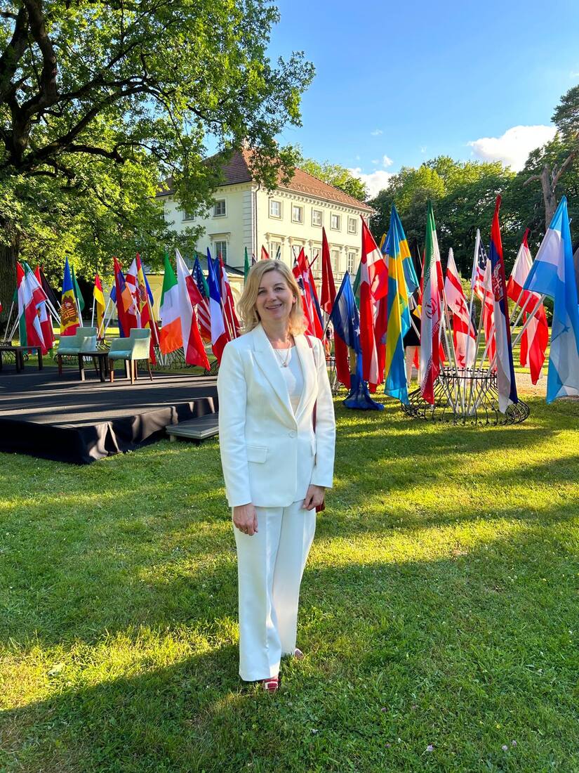 An international institutional event, framed by rows of national flags